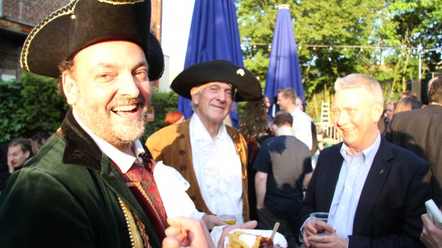 Two partygoers dressed as classic pirates discuss with Christian Engström, MEP